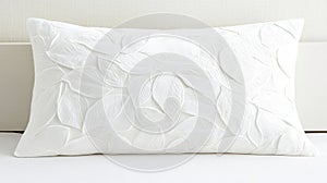 A white pillow with a leaf pattern.