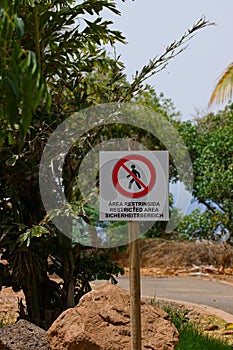 Image of a sign prohibiting access to a path in a natural park in English, German and Spanish