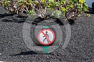 The image of the sign that prohibits the pedestrian crossing, garden in Lanzarote, Canary Islands