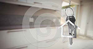 Image of silver house keys and house shaped key fob hanging over an out focus kitchen 4k