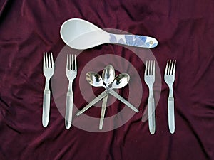 Simple set of fork and spoon isolated on violet background.