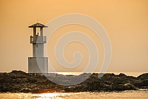 Image of small lighthouse against a tropical ocean sunset and smooth water at Khao Lak Beach in Phang Nga,Thailand.