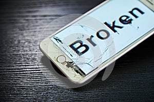 Image of smartphone with broken screen and the word Broken on it