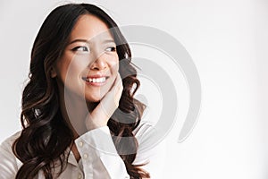 Image of smiling chinese woman with long dark hair looking aside