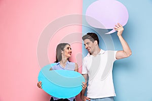 Image of smiling couple holding copyspace bubbles for announcement, isolated over colorful background