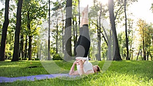 Image of smiling middle aged woman in fitness clothes doing stretching and yoga exercises. WOman meditating and doings