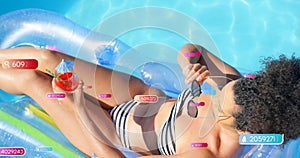 Image of social media notifications over biracial woman sunbathing in pool