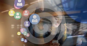 Image of social media people icons over woman using smartphone and tablet