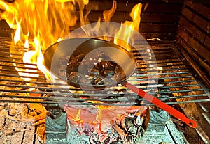 Image of some chestnuts roasted in a pan on the fire of the fireplace, a delicious delicacy and a pleasure.