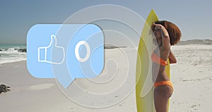 Image of speech bubble with thumbs up digital icon and numbers, woman with surfboard on beach