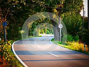 Image of speed limit of 30 kmh next to a curvy road