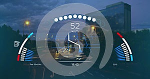 Image of speedometer, gps and charge data on interface, over sped up city traffic at night photo