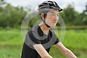 Image of sporty man riding a bicycle on country road. Travel, sport and active lifestyle concept