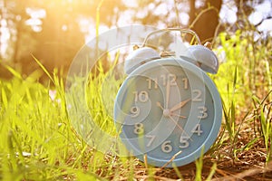 Image of spring Time Change. Summer back concept. Vintage alarm Clock outdoors.