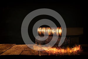 image of stack of antique books over wooden table and dark background.