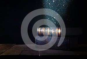 image of stack of antique books over wooden table and dark background.