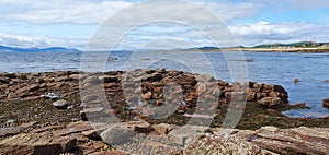 The image of a stoney beach in Scotland on a beautiful day