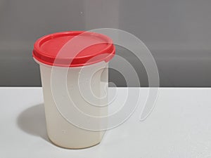 Image of storage container by Tupperware brand isolated on grey background.