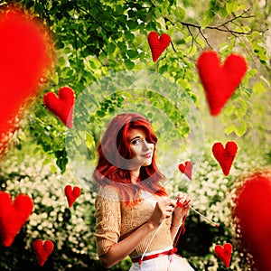 The image in the style of fantasy Valentine's Day. Young beautiful girl knits red hearts that fly around it. photo