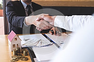 Image of successful deal of real estate, Broker and client shaking hands after signing contract approved application form,