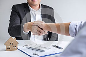 Image of successful deal of real estate, Broker and client shaking hands after signing contract approved application form,