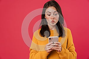 Image of surprised brunette girl using mobile phone