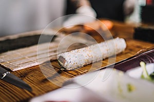 Image of a sushi master preparing a california roll