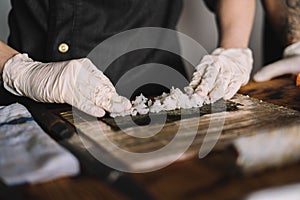 Image of a sushi master preparing a california roll