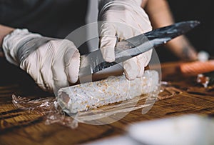 Image of a sushi master preparing a california roll