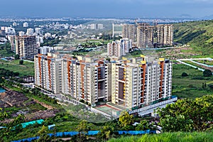 Image of tall buildings under construction near the hill in Pune, Maharashtra.