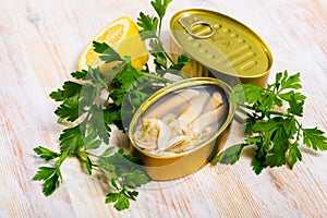 Tasty sea natural navajas in open tin can with lemon and greens photo
