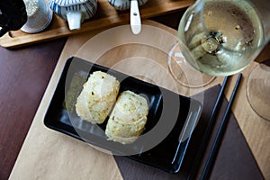 Image of tasty triangular onigiri from rice at black plate photo