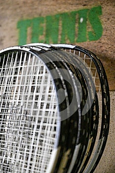 Image of tennis rackets propped up against a wall in a room