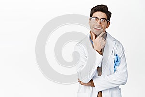 Image of thinking doctor with pleased smiling face, looking up thoughtful, standing over white background