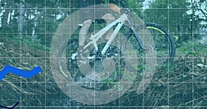 Image of three blue lines and statistics recording over man cycling in forest in the background photo