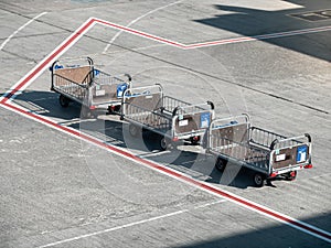 Image of three gound service empty carts for carrying and loading luggage and bags in airplane
