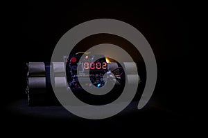 Image of a time bomb against dark background. Timer counting down to detonation illuminated in a shaft light shining through the d