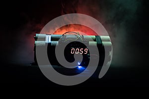 Image of a time bomb against dark background. Timer counting down to detonation illuminated in a shaft light shining through the d