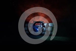 Image of a time bomb against dark background. Timer counting down to detonation illuminated in a shaft light shining through the d