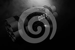 Image of a time bomb against dark background. Timer counting down to detonation illuminated in a shaft light shining through the d