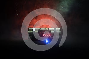 Image of a time bomb against dark background. Timer counting down to detonation illuminated in a shaft light shining through the d