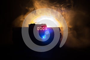 Image of a time bomb against dark background. Timer counting down to detonation illuminated in a shaft light shining through the d