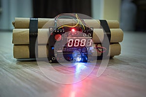 Image of a time bomb on floor. Timer counting down to detonation illuminated in a shaft light shining through the darkness