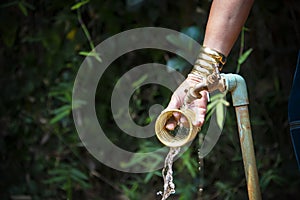 Image of traditional old karen woman cleaning the golden circle necklace for karen people, Feb 2018, Chiang Rai, Thailand