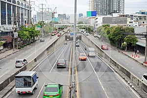 Image of traffic on a road running back and forth in a city in Bangkok.