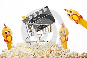 Image of trolley clapper board rubber chicken pop corn white background