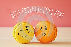 Image of two cute macaroons with drawn smiley faces