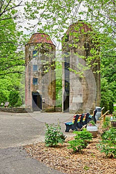 Two silos in Bernheim Forest park with nearby rainbow benches and woods in summertime