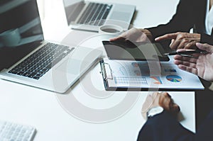 Image of two young business executives using touchpad at meeting