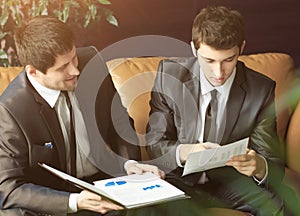 Image of two young businessmen discuss the project at a meeting in the office